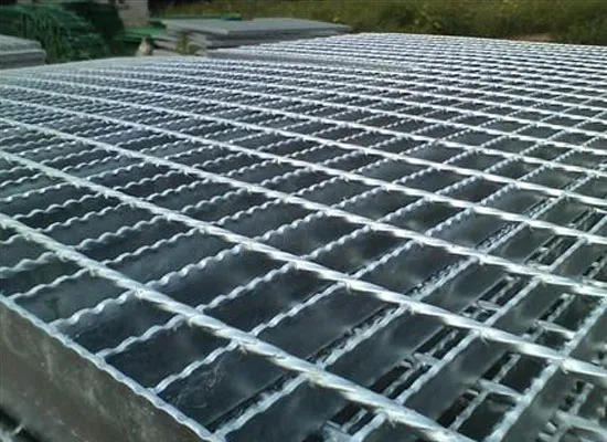 Close-up of grating platform with support frame and railing post in industrial building; low diagonal view
