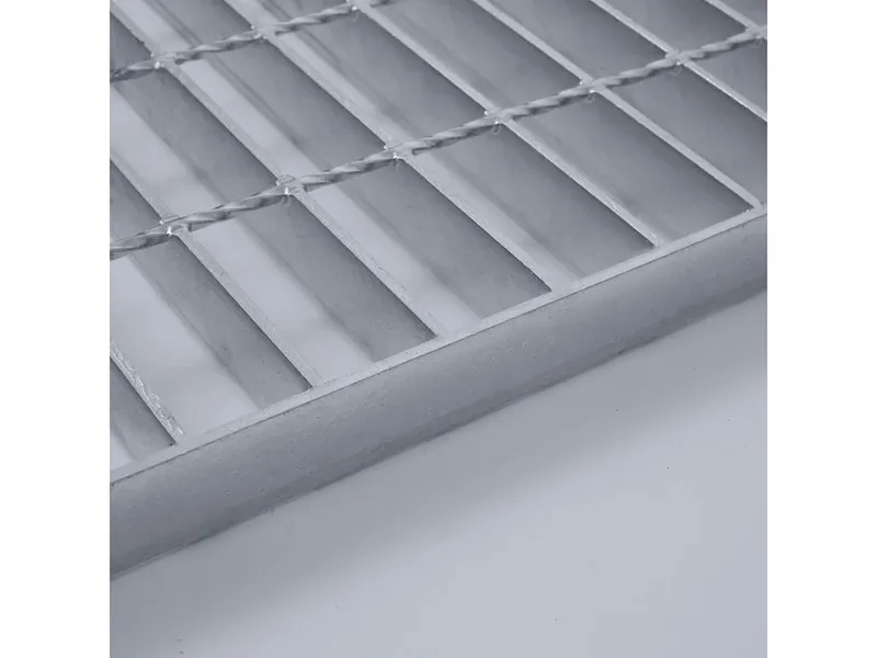 Overhead close-up of galvanized grating decking on steel walkway showing mesh and sheen