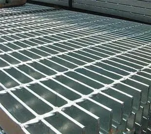 Hot-dip galvanized welded grating panels stacked in bundles in warehouse; high angled view