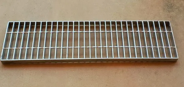 Press-locked steel grating panel; galvanized; diagonal three-quarter view on white background; notch-locked cross bars without welds