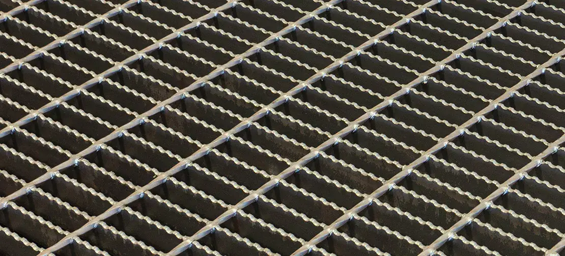 Trench drain grating strip along road edge with curbs; outdoor daylight