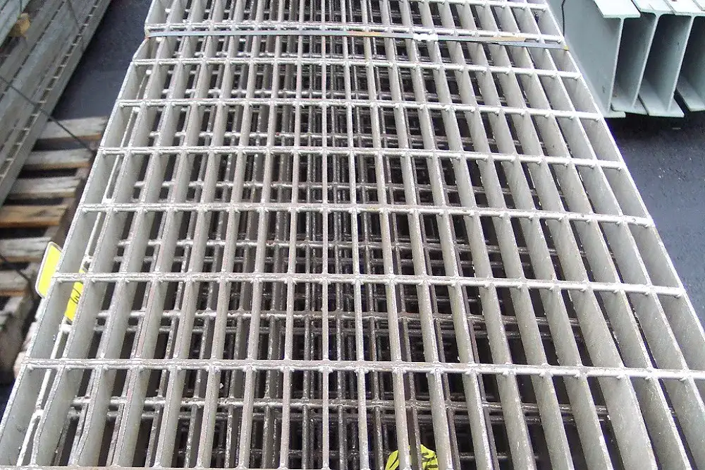Grating-covered trench drain along factory floor; linear perspective
