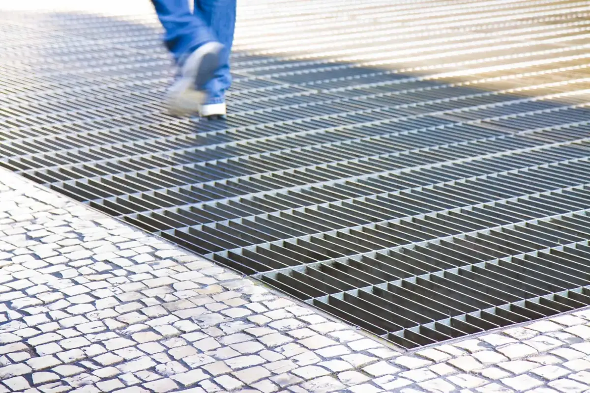 Grating-covered walkway between plant buildings with safety-yellow handrails