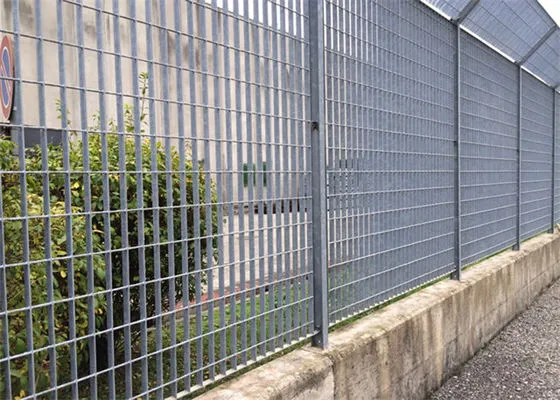 Stack of hot-dip galvanized welded grating panels with plain bearing bars resting on wooden support in outdoor factory yard