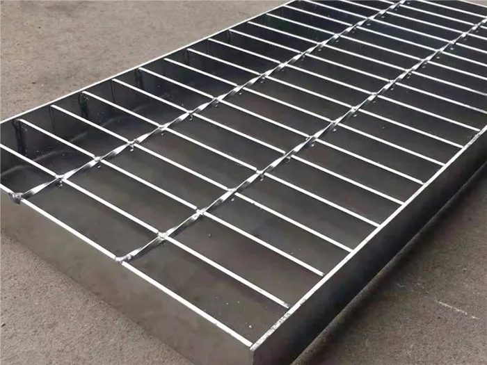 Bright hot-dip galvanized welded grating panel standing upright in workshop; three-quarter view; factory background