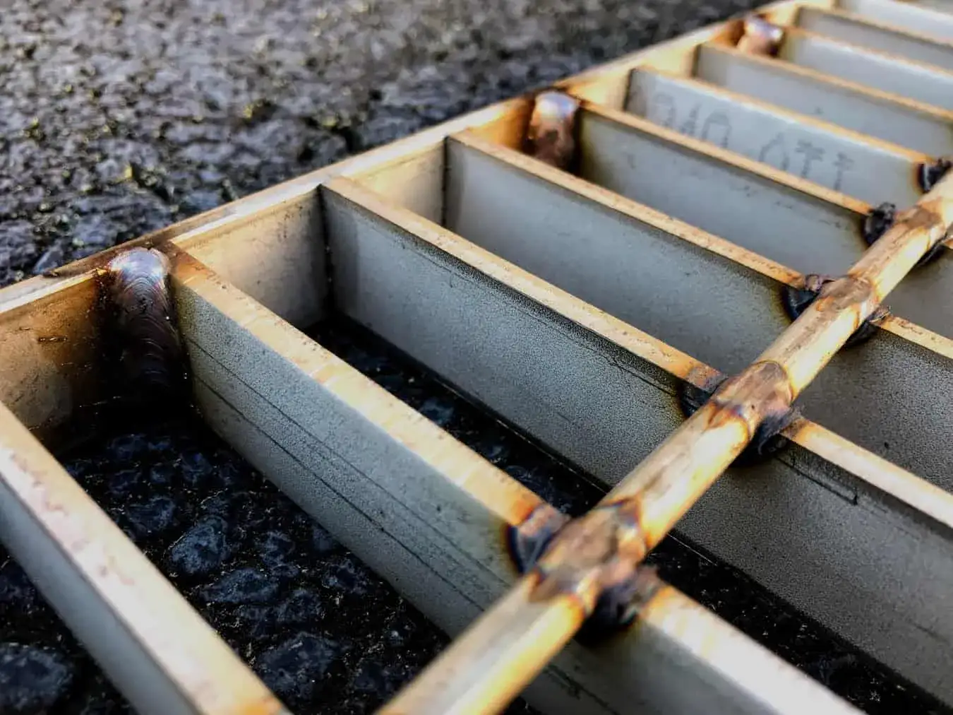Welded steel bar grating close-up; galvanized; low angle on white background