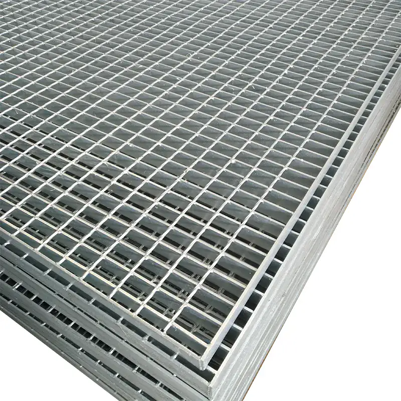 Stack of hot-dip galvanized welded grating panels photographed diagonally from above; clear mesh pattern