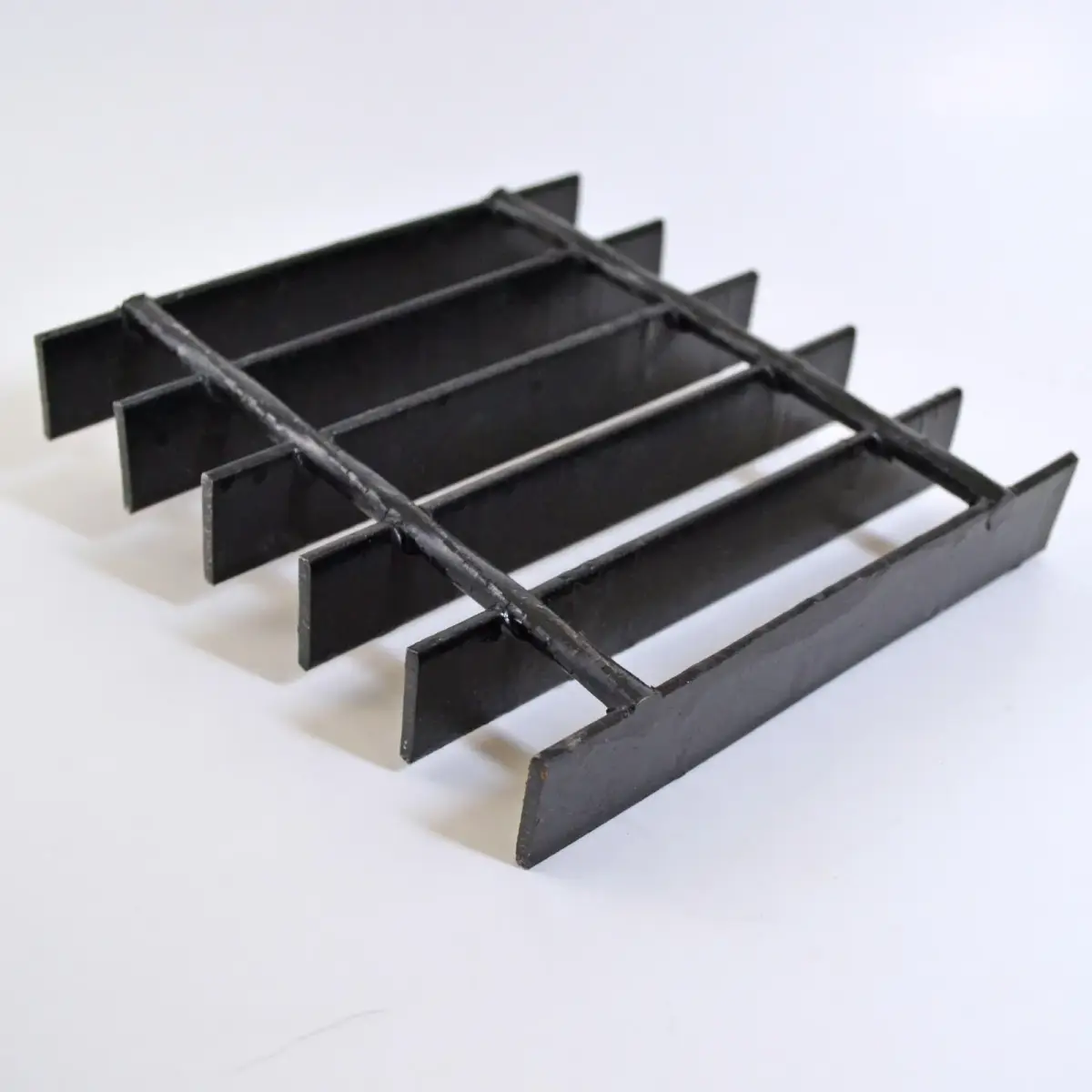 Stacked galvanized grating panels shot low-angle against blue sky