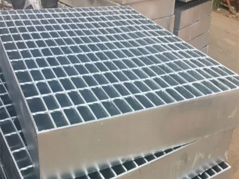 Hot-dip galvanized welded steel grating panels stacked in factory yard; banded edges; high three-quarter angle